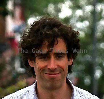 Comedy actor Stephen Mangan walking with a shopping bag in North London London.