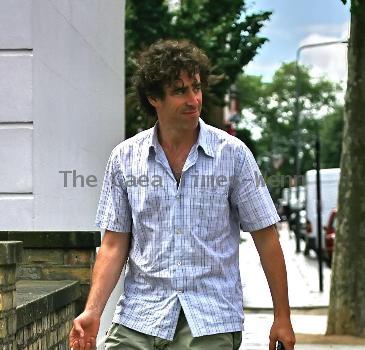 Comedy actor Stephen Mangan walking with a shopping bag in North London London.