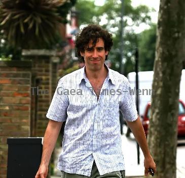 Comedy actor Stephen Mangan walking with a shopping bag in North London London.