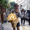 Kelly Rowland walking to a recording studio in central London, carrying a fur coat. London.