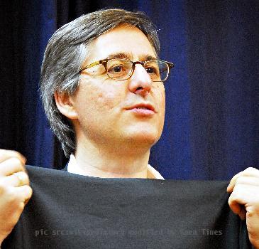 Dan Lyons, aka Fake Steve Jobs, holding up an Apple turtleneck for size at an event at Kepler