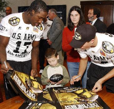 wSergio Kindle (left) a linebacker from Dallas and Chris Caflisch, a wide receiver from San Antonio sign posters and miniature footballs for children from the Warm Springs Rehabilitation Center in San Antonio. Both players