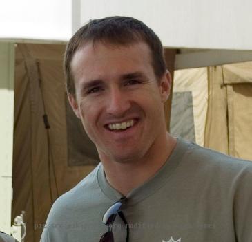 Camp Arifjan, KW - New Orleans Saints quarterback Drew Brees poses for a photo with Petty Officer 3rd Class Corey Adam at the Expeditionary Medical Force - Kuwait hospital on camp Thursday. The NFL star is touring the Mid