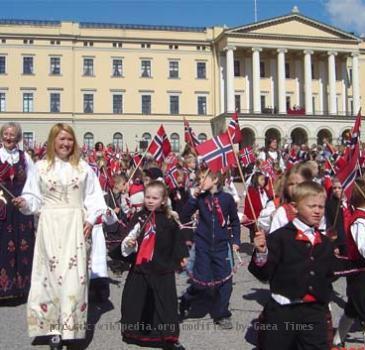Norwegians dressed in bunad parading in front of the royal family on May 17th.