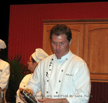 Bobby Flay performing a cooking demonstration in Green Bay, Wisconsin