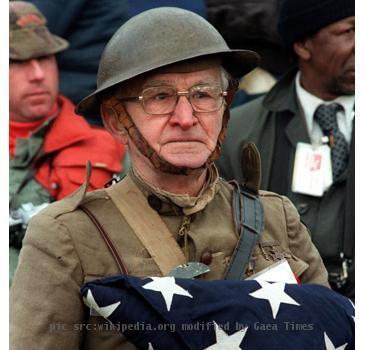 
Joseph Ambrose, an 86-year-old World War I veteran, attends the dedication day parade for the Vietnam Veterans Memorial. He is holding the flag that covered the casket of his son, who was killed in the Ko