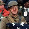 
Joseph Ambrose, an 86-year-old World War I veteran, attends the dedication day parade for the Vietnam Veterans Memorial. He is holding the flag that covered the casket of his son, who was killed in the Ko