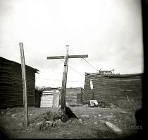 A man cut a lonely figure far off between run down buildings and a dilapidated caravan  I thought the scene looked pretty bleak  until it started to pour  A lot of people in poverty stricken areas turn to religion for hope and comfort  This clothesline  although probably unintentionally  doubled as a cross  reflecting people s beliefs in Langa