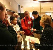 Museum docent and group leader  Gabriella Cantoni  hands out educational bookmarks to students from Suitland High School in Forestville during Brain Awareness Week at the National Museum of