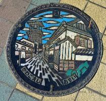 one was built in 1893  after the great fire that burned most of the town  If you look closely at the bottom  right part of this picture you can see some newlyweds having their pictures taken  The bell and tower are also featured on Kawagoe s manhole drain covers    Kawagoeshi = ????? = ??? and shi means  city  in Japanese   ??? = ?? and osui means