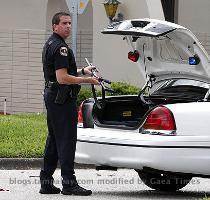 A Largo Police officer unloads a shotgun Wednesday after responding to a call that Neil Marshall James had shown up at his estranged girlfriend s place of work trying to see her  Police say