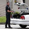 A Largo Police officer unloads a shotgun Wednesday after responding to a call that Neil Marshall James had shown up at his estranged girlfriend s place of work trying to see her  Police say