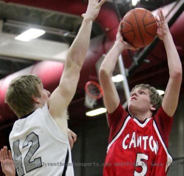 Canton s Paul Baumgart lifts a shot over the outstretched arm of Plymouth s Brennen Beyer Friday night   photo courtesy of PlymouthPictures com