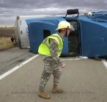 gusts topping 60 mph knocked out power to hundreds of thousands of customers and disrupted travel in parts of the eastern and central USA Photo   A emergency worker struggles against the wind at the scene of an overturned truck in Henderson County  Ky   on Wednesday   By Mike Lawrence  The Gleaner  via AP